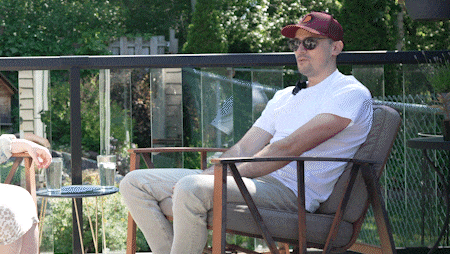 Alex Wolf in conversation with a guest on the patio